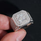 Angled view showing wide pave band and square cluster halo of moissanite ring on dark surface
