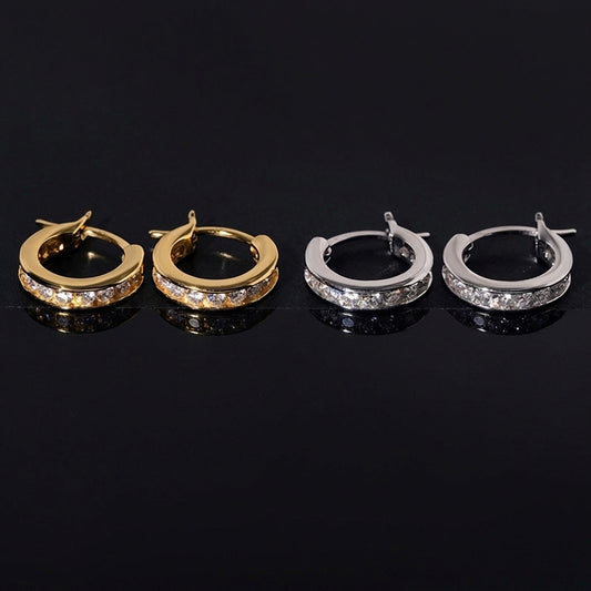 Silver channel set moissanite huggie hoop earrings resting on velvet display tray