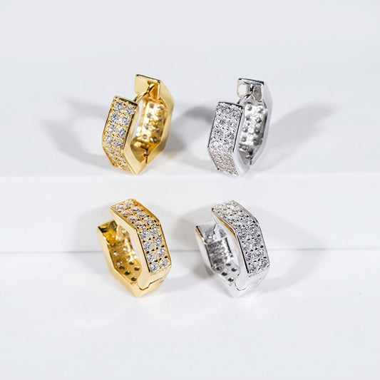 Iced out gold and silver hexagon geometric moissanite huggie hoop earrings on white display backdrop