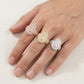 Person wearing three color iced out hamsa hand moissanite baguette statement rings on fingers