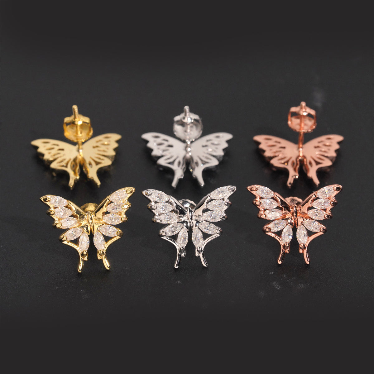 Three-tone iced out marquise butterfly moissanite stud earrings showing posts and screw backs on black background