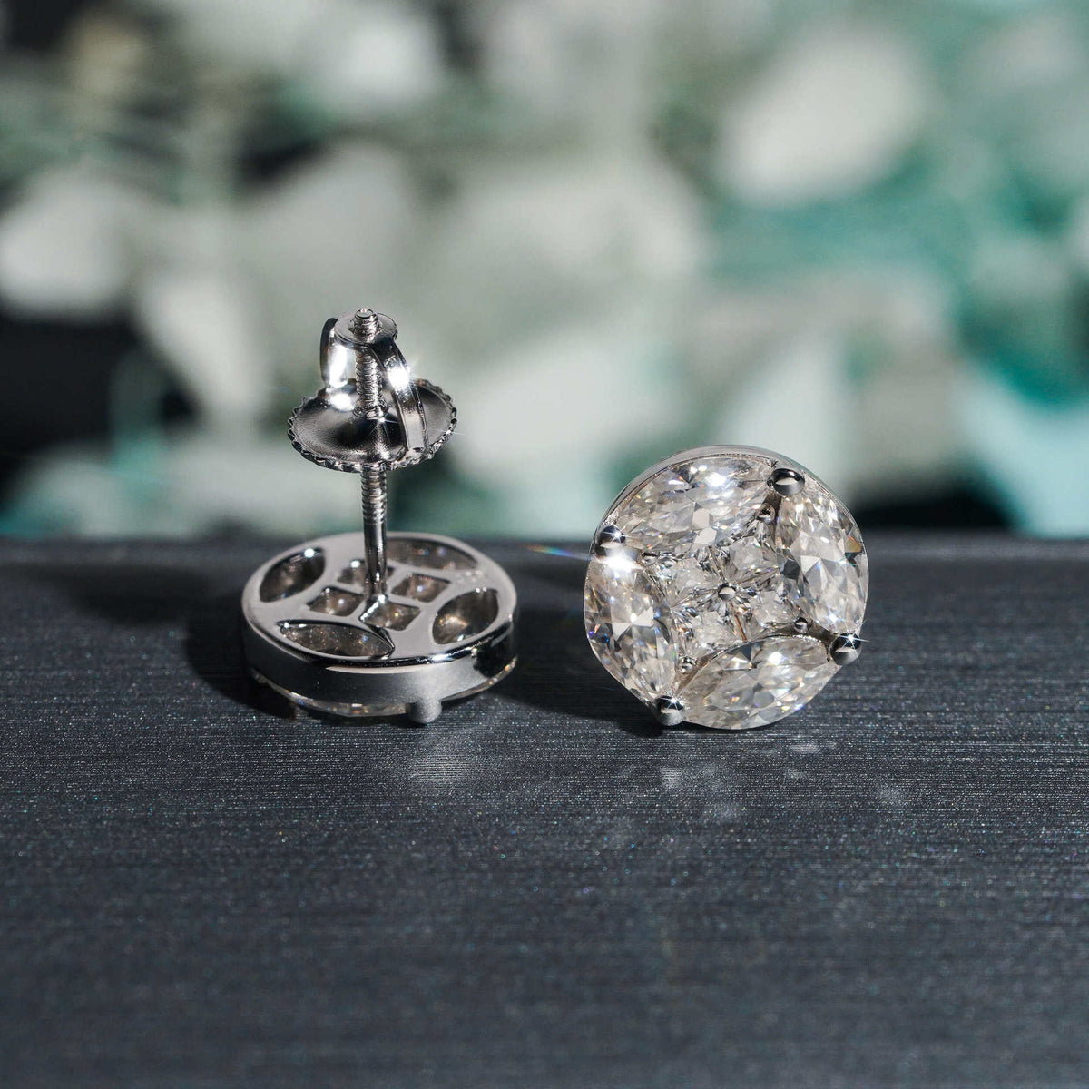 Gold and silver iced out marquise cluster round moissanite stud earrings displayed on GRA card