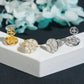 Yellow gold and silver iced out marquise cluster round moissanite stud earrings on white pedestal box