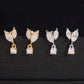 Iced out marquise leaf dangle solitaire moissanite stud earrings in yellow gold and silver on dark surface
