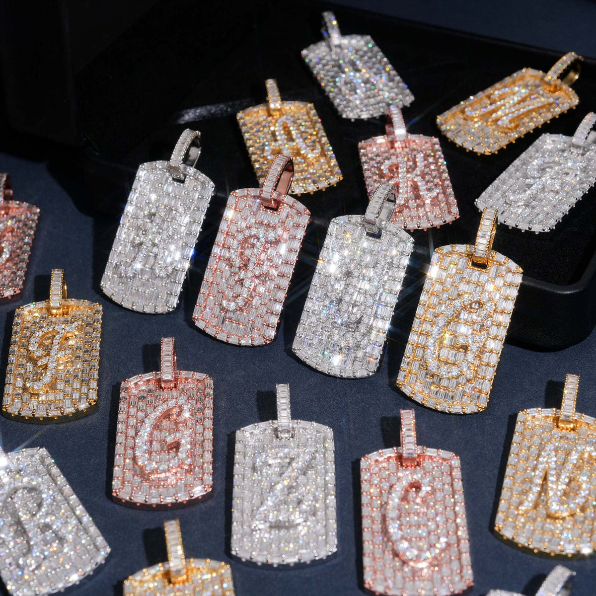 Assorted iced out moissanite baguette initial dog tag pendants in various letters and gold tones
