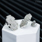 Pair of silver iced out money sign dollar sign moissanite stud earrings on white pedestal box
