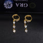 Gold and silver iced out pear cut 3-stone drop dangle huggie hoop moissanite earrings showing hinged clasps