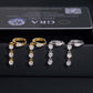 Iced out pear cut and 3-stone drop dangle huggie hoop moissanite earrings in gold and silver in front of GRA card   