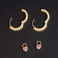 Yellow gold iced out huggie hoop moissanite earrings showing detachable pink heart charms and hinged clasp