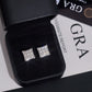 Pair of iced out princess cut square cluster moissanite stud earrings in leather box with GRA report card