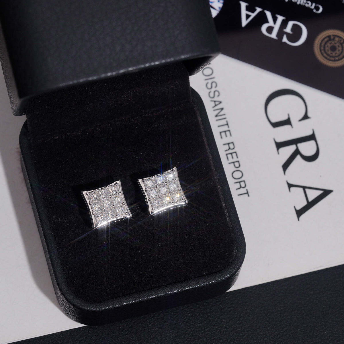 Pair of iced out princess cut square cluster moissanite stud earrings in leather box with GRA report card