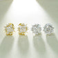 Iced out sunburst starburst solitaire moissanite stud earrings in yellow gold and silver under spotlight