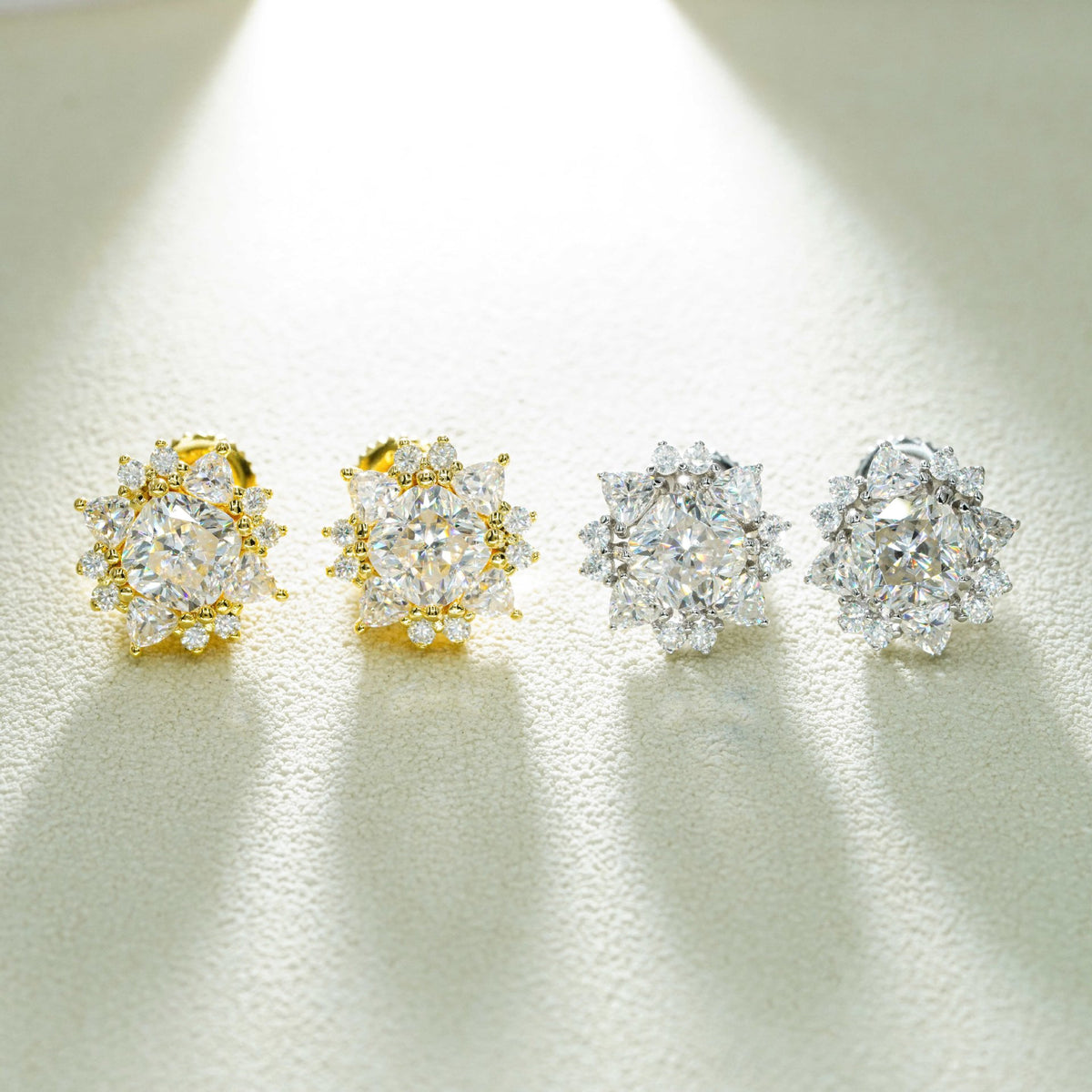 Iced out sunburst starburst solitaire moissanite stud earrings in yellow gold and silver under spotlight