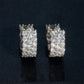 Silver iced out triple row moissanite huggie hoop earrings with pave setting on dark surface