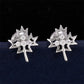 Silver iced out weed leaf maple leaf moissanite stud earrings aligned on dark background