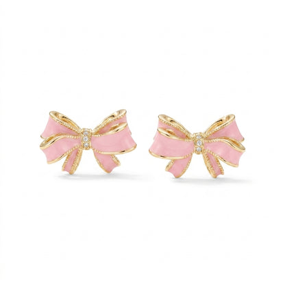 Kendra Scott x LoveShackFancy bow gold stud earrings with pink enamel and pavé crystal accents on white background.