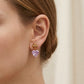 ZERRA Tory Burch gold and pink crystal heart drop earrings with sparkling gemstone accents on a white background