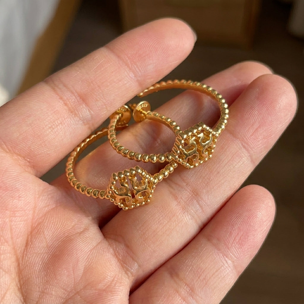 Zerra Jewelry Tory Burch Milgrain Hex Hoop Earrings with geometric hexagon design in gold-tone metal on a white background.