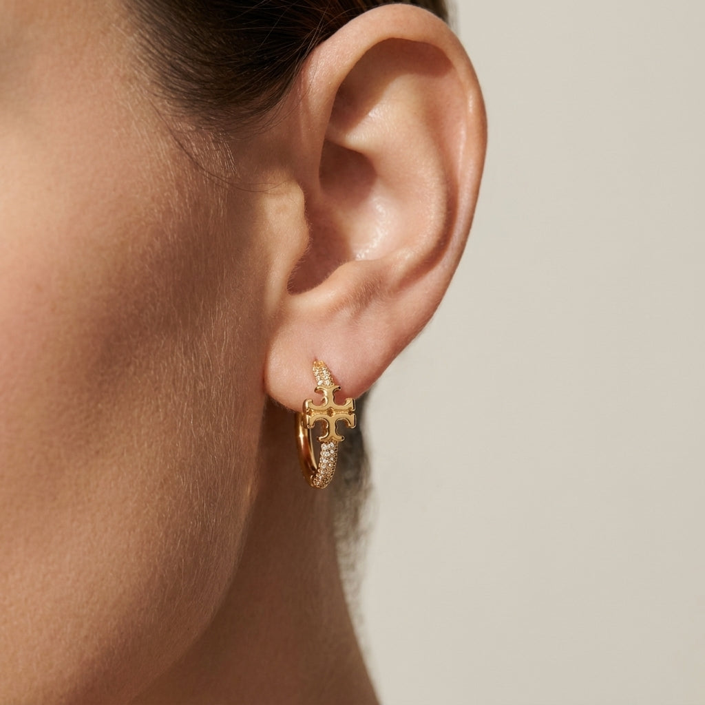 ZERRA Tory Burch Small Eleanor gold logo hoop earrings with monogram design, showcasing sleek, elegant jewelry style.