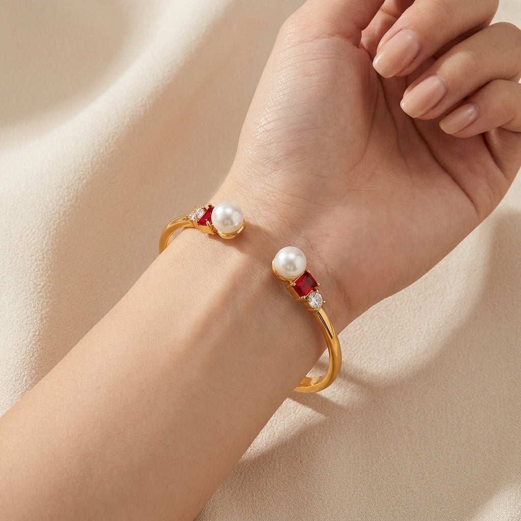 Macro detail of the vibrant red enamel and soft white pearls on the Kate Spade wisdom bracelet