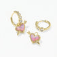 Kendra Scott Ari heart earrings demonstrating the removable charm and plain crystal huggie hoop option.