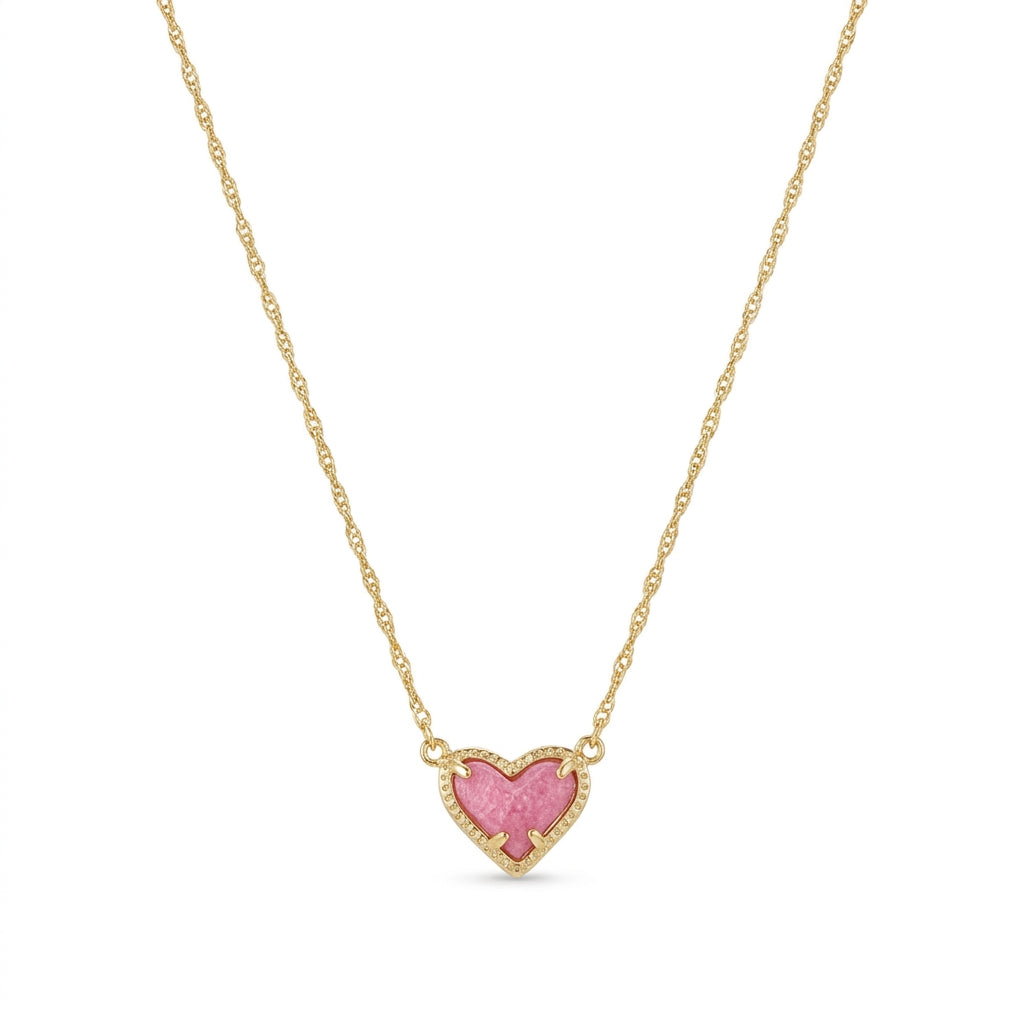 Kendra Scott Ari Heart short pendant necklace in gold featuring an asymmetrical pink stone charm.