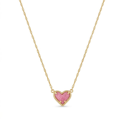 Kendra Scott Ari Heart short pendant necklace in gold featuring an asymmetrical pink stone charm.