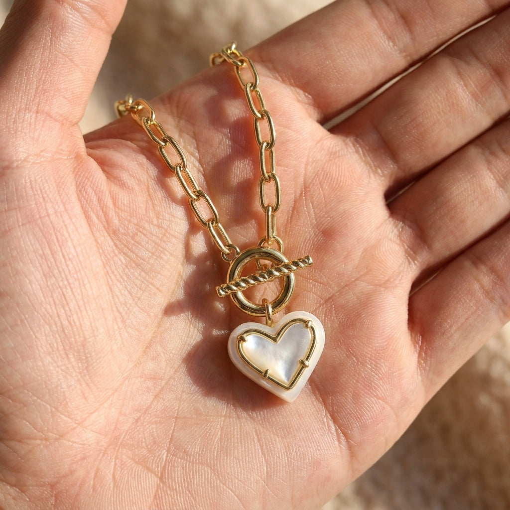 Hand-held size reference of the Ari Heart Pearl Necklace to show the delicate pendant scale