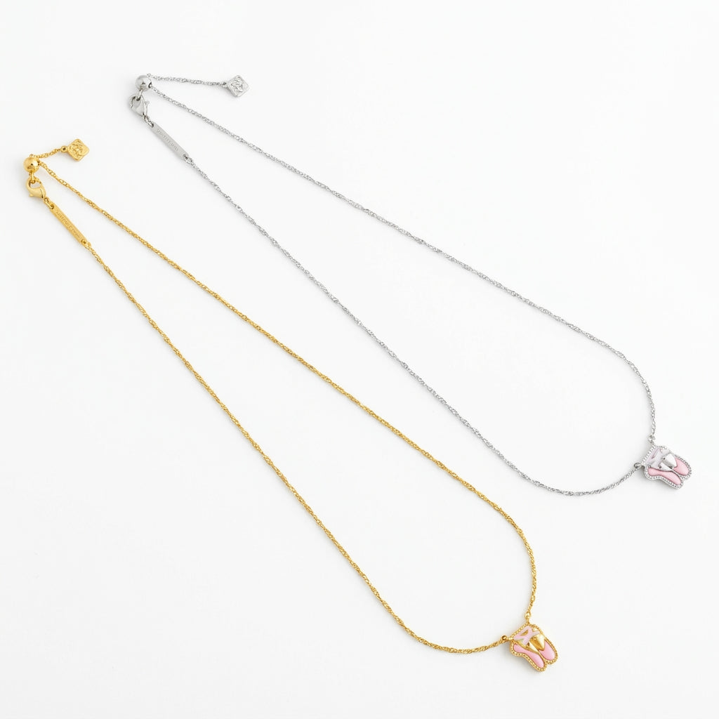 Two Kendra Scott ballet slippers necklaces displayed in yellow gold and silver metal chain options.