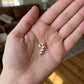 Hand-held size reference of the Kendra Scott Candy Cane Necklace for delicate scale