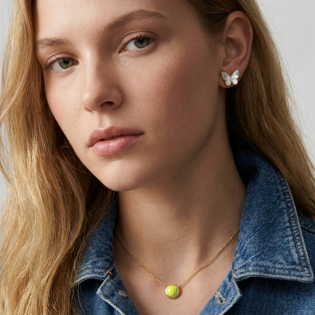 Blonde model wearing the gold Kendra Scott tennis pendant necklace with a chartreuse green stone