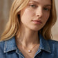Blonde model wearing the gold Kendra Scott Brynne shell pendant necklace with a denim jacket.