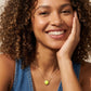 Smiling model showcasing the Kendra Scott gold tennis ball pendant necklace in chartreuse magnesite.
