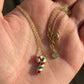 Hand-held size reference of the multicolor Candy Cane Necklace to show the delicate pendant scale