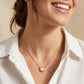 Close-up of a smiling model wearing the rose gold pink mother of pearl Brynne shell necklace.
