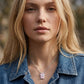 Model in a denim jacket showcasing the silver Kendra Scott ballet short pendant necklace.