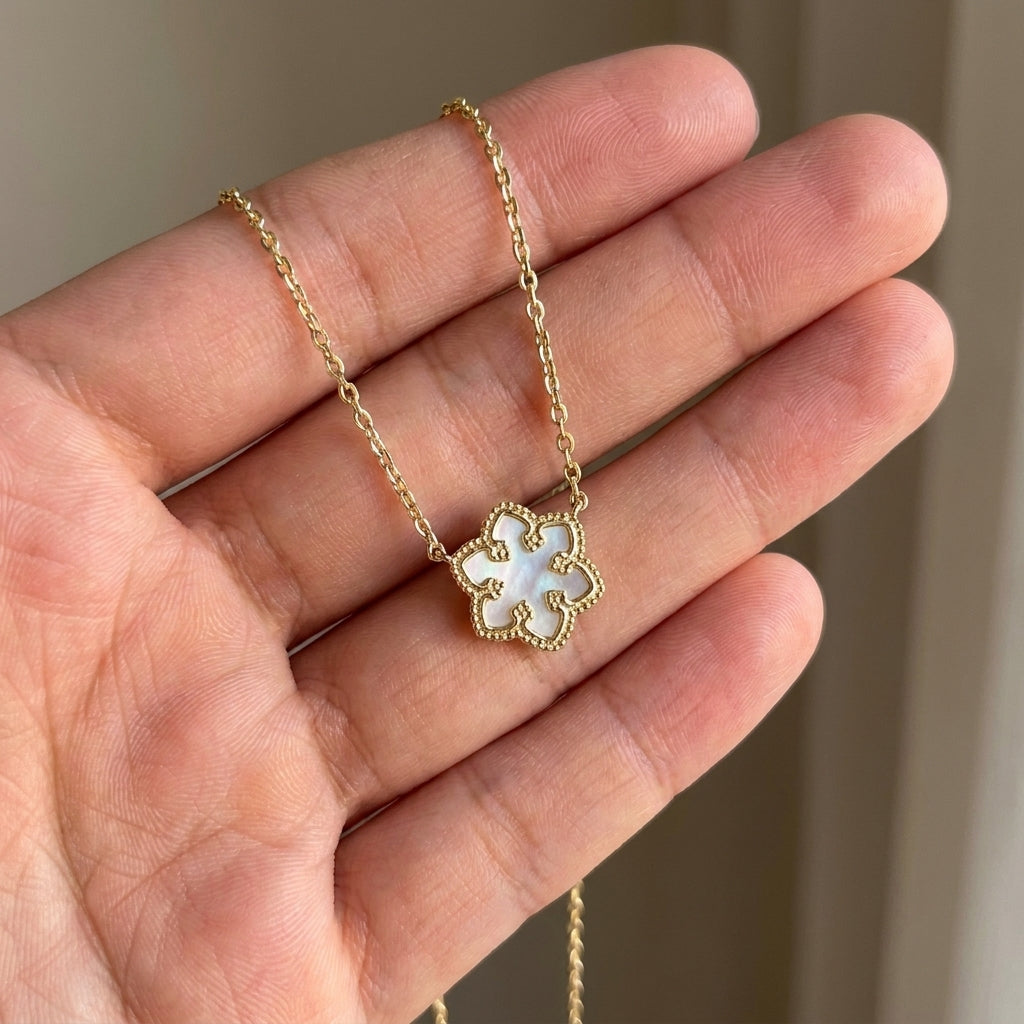 Hand-held size reference of the Kendra Scott Snowflake Necklace for delicate scale