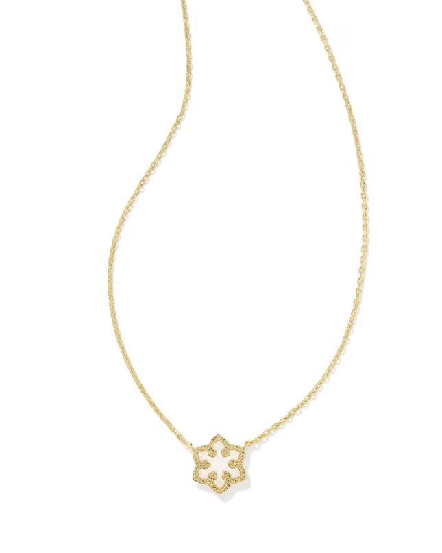 Macro detail of the gold snowflake pendant showing intricate cutouts and crystals