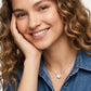 Smiling female model with curly hair showcasing the white mother of pearl short pendant necklace