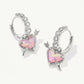Silver hoop earrings with pink heart and arrow design on a white background