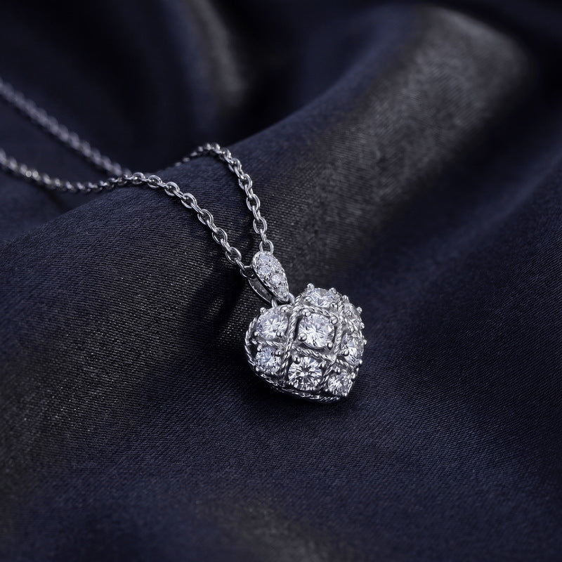 Lab grown diamond quilted lattice heart pendant resting on dark silk fabric.