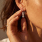 Model wearing lab grown diamond three stone past present future drop earrings.