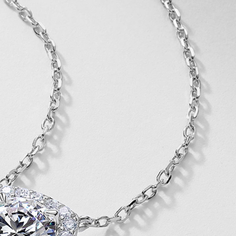 Close-up view of delicate silver cable chain attached to cushion halo lab diamond pendant.