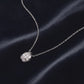 Pear cut lab grown diamond faceted bezel pendant resting on dark navy silk fabric.