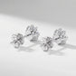 Pair of lab grown diamond snowflake stud earrings resting on white clean background.