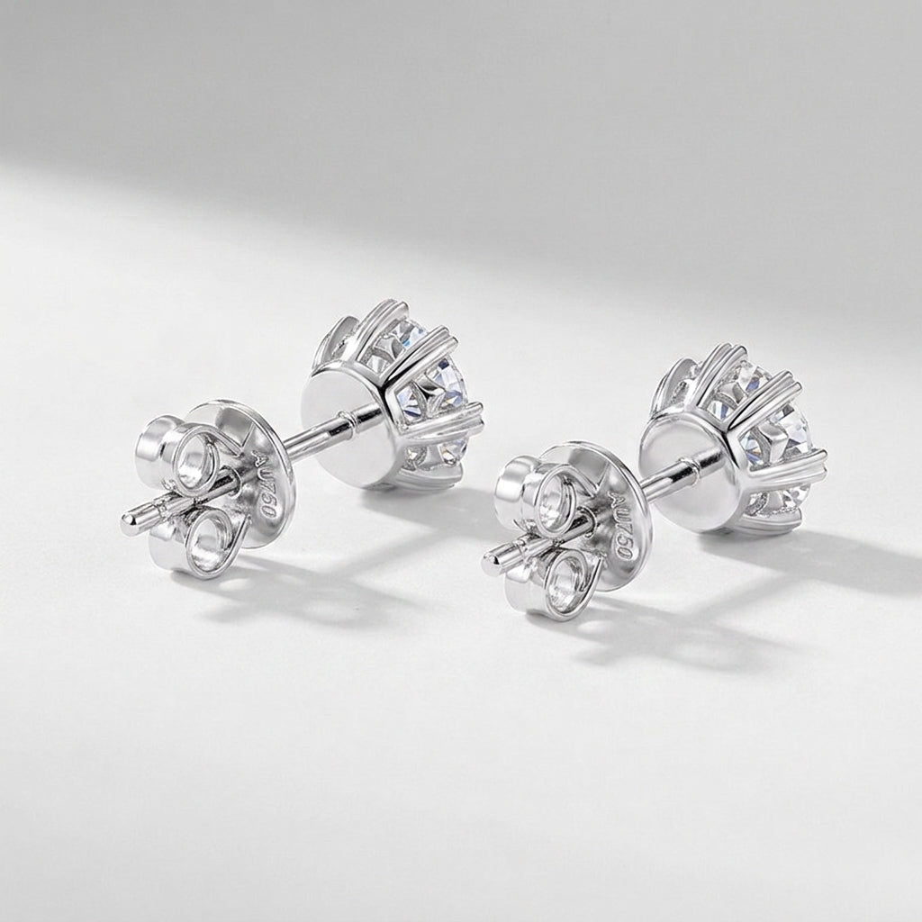Pair of lab grown diamond snowflake stud earrings resting on white clean background.