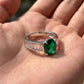 Silver ring with a green gemstone held in a hand