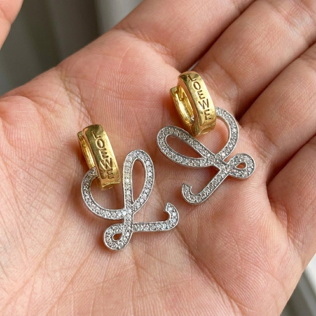 Hand-held size reference of the Loewe Anagram L earrings to show the delicate statement scale