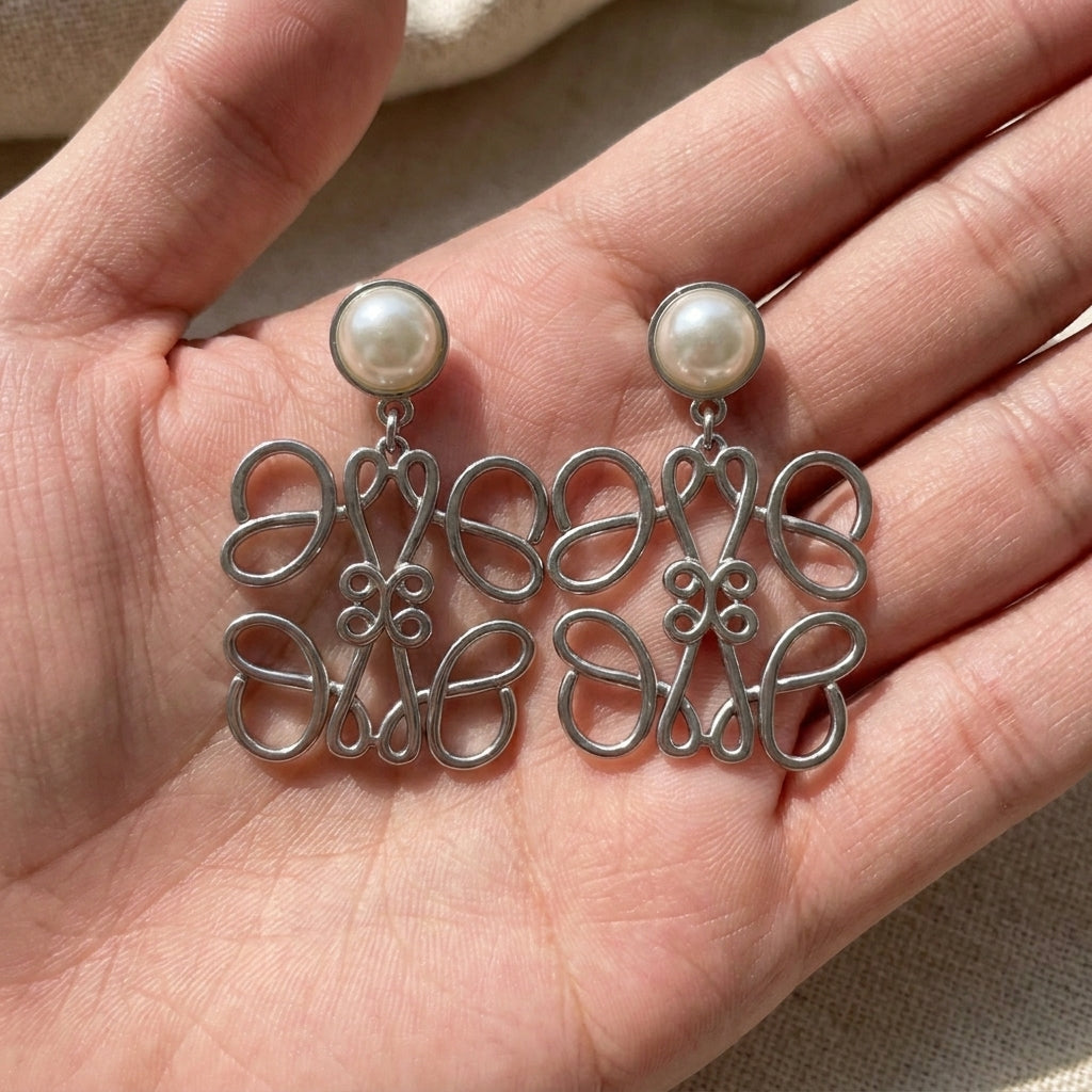 Hand-held size reference of the Loewe Silver Pearl Earrings to show the true pendant scale