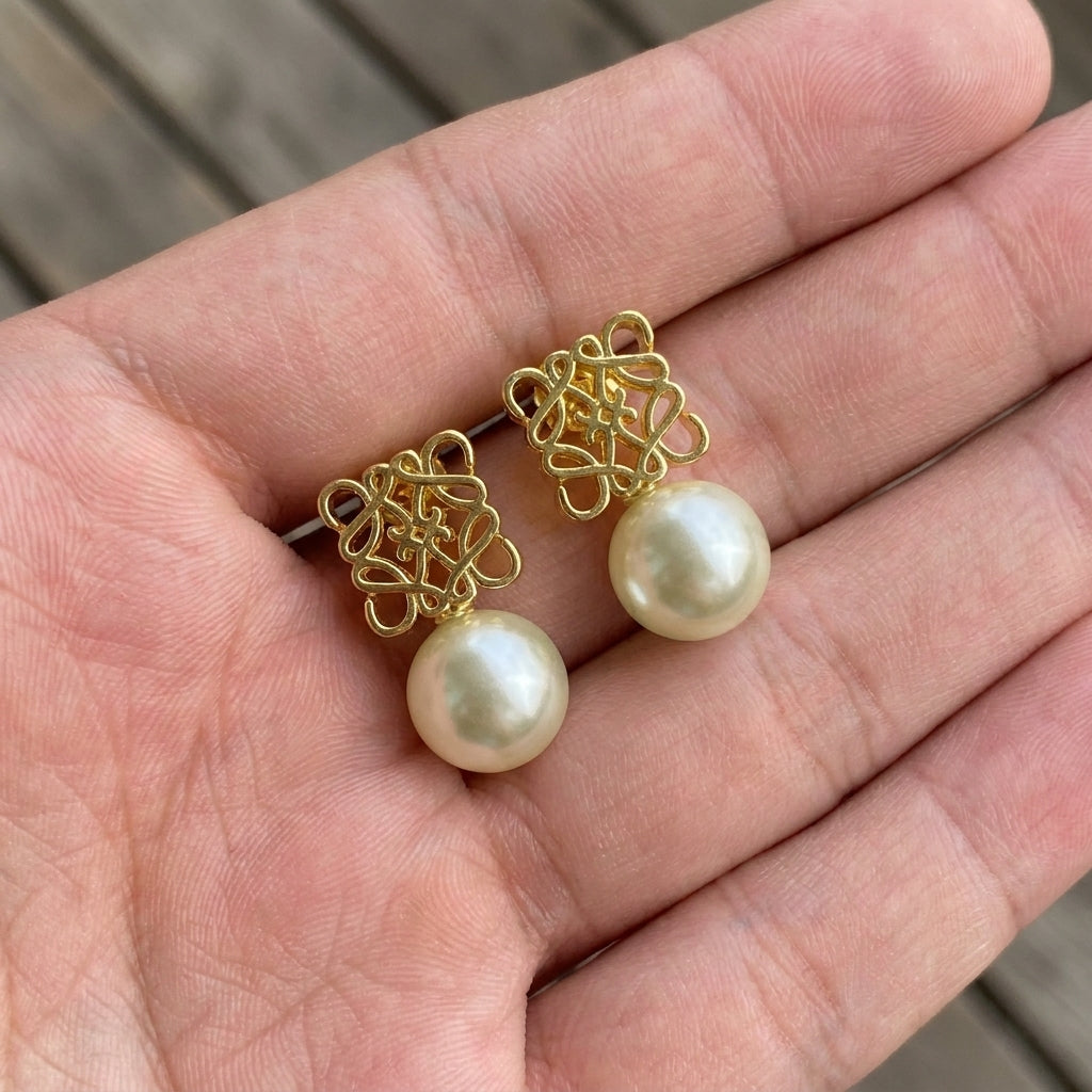 Hand-held size reference of the Loewe Geometric Pearl Earrings for true scale